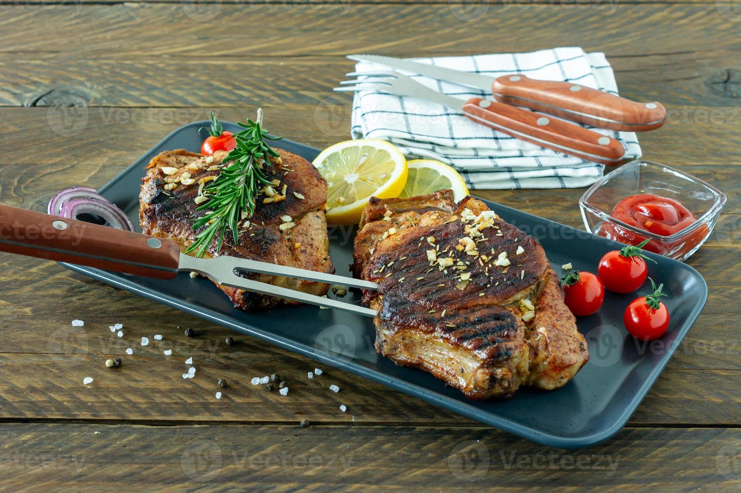 frisches saftig gebratenes rotes fleisch auf keramikplatte auf holzbrett, mit gewürzen und gemüse. Restaurantessen, leckeres Gericht foto
