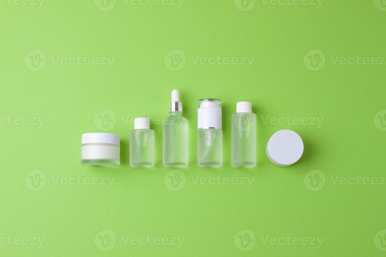 kosmetische hautpflegeprodukte auf grünem hintergrund. flach liegend, kopierraum foto