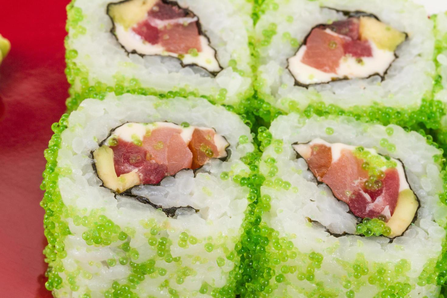 Tobiko Spicy Maki Sushi - heiße Rolle mit verschiedenen Arten von Rogen des fliegenden Fisches draußen. Thunfisch, Avocado und grüner Salat im Inneren foto