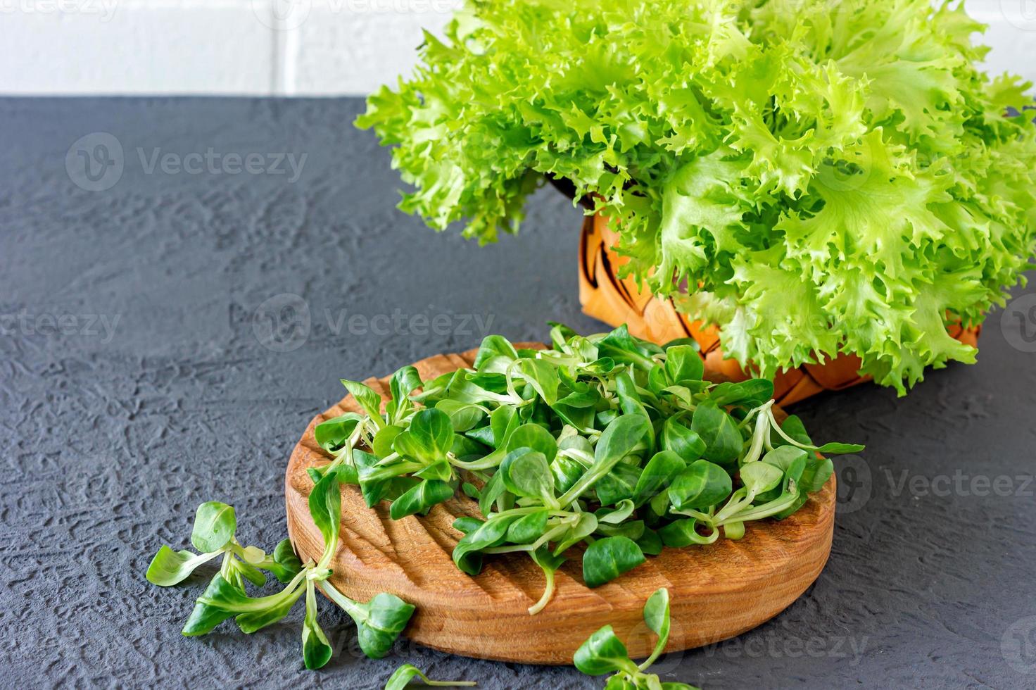 Valerianella locusta, Feldsalat, Feldsalat. frische grüne Maissalatblätter auf Holzschreibtisch foto