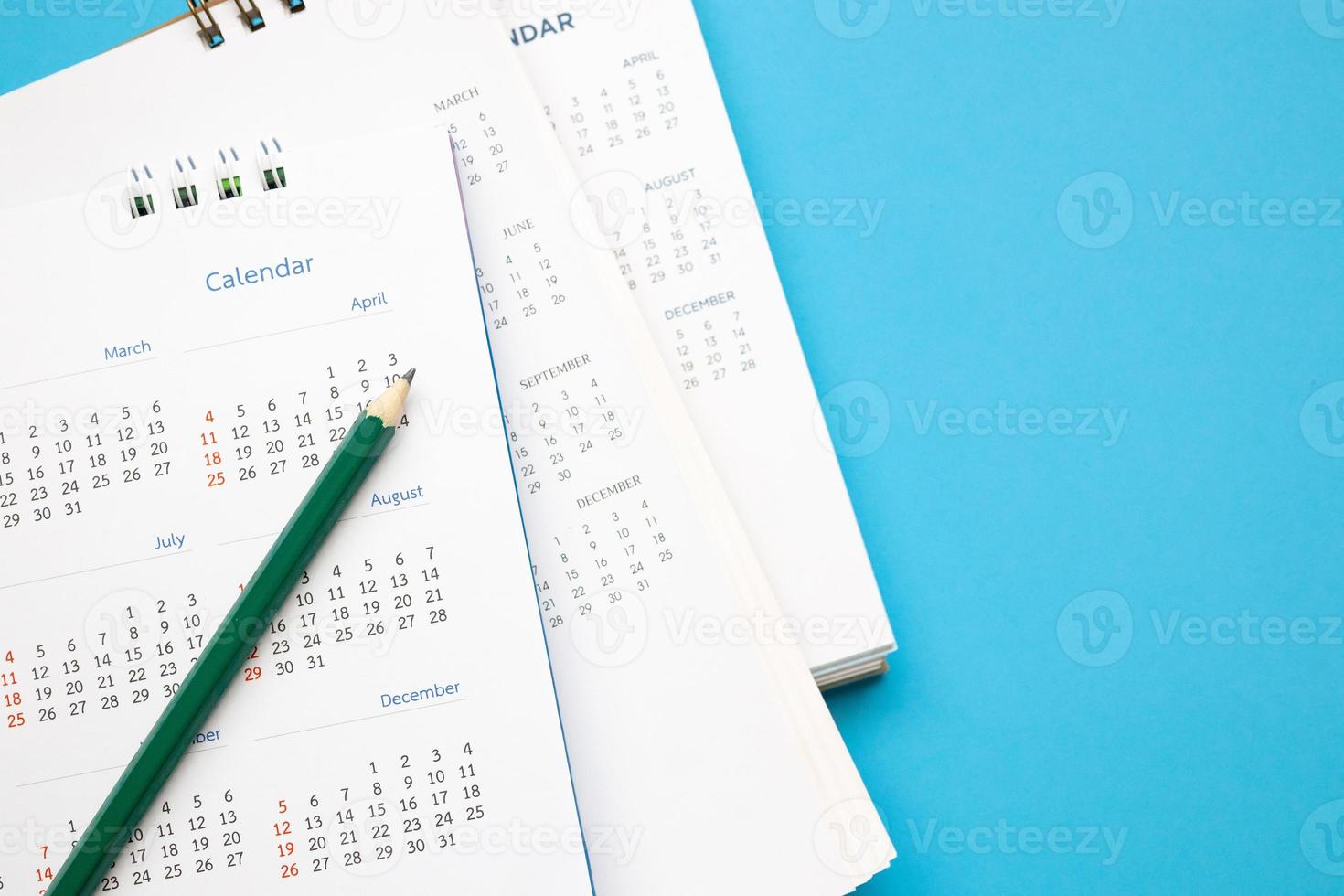 Kalenderblatt mit Bleistift hautnah auf blauem Hintergrund Geschäftsplanung Termin Meeting Konzept foto