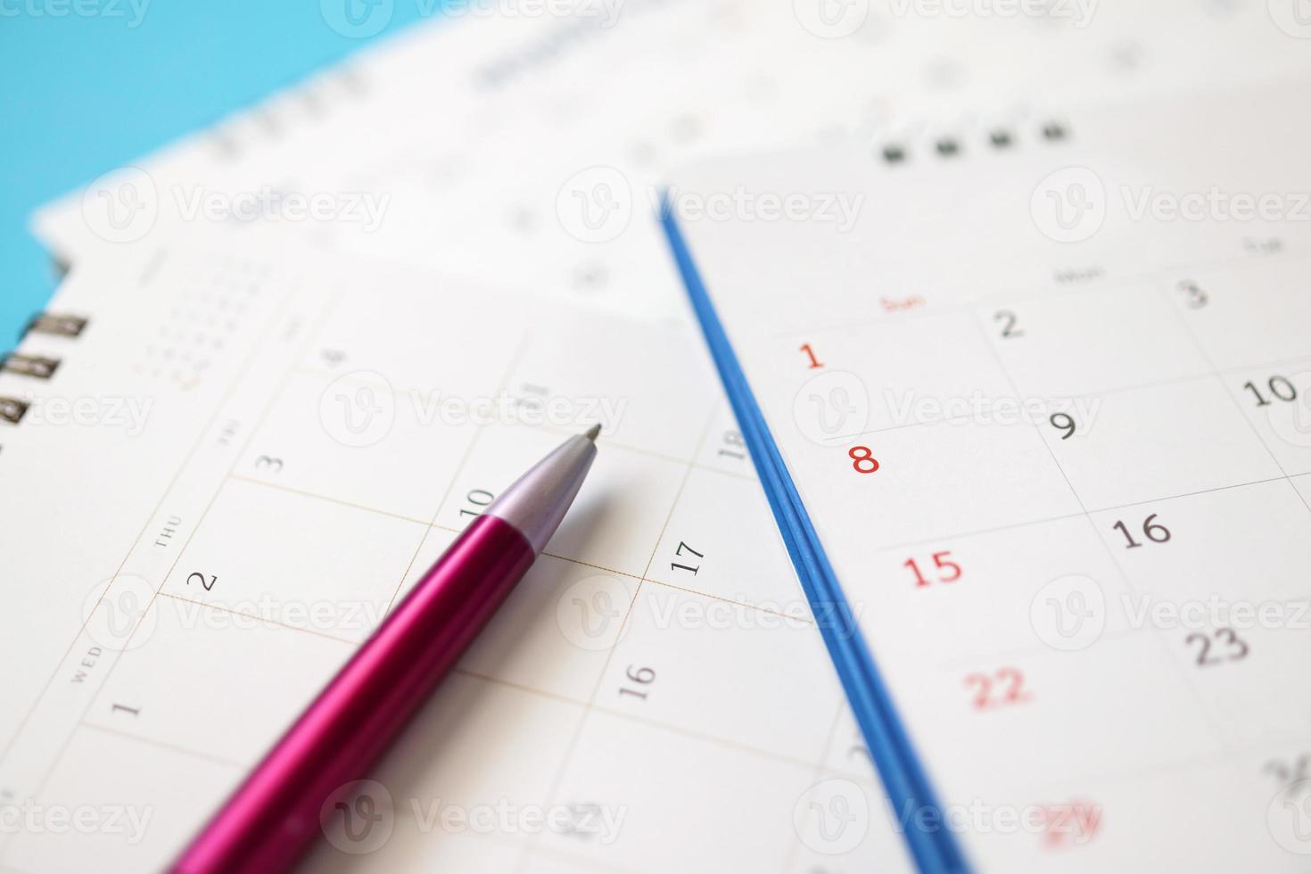 Kalenderseite mit Stift hautnah auf blauem Hintergrund Geschäftsplanung Termin Meeting Konzept foto