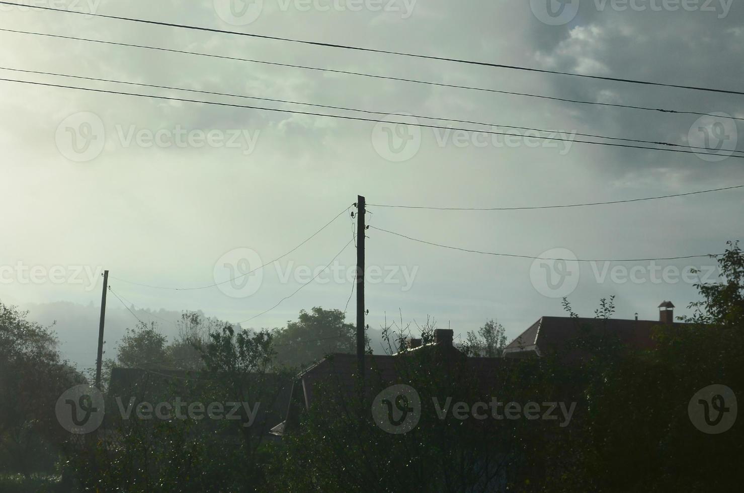 Das Mehrfamilienhaus liegt vor einer dicken Nebelschicht. leben in einer bergigen gegend in den karpaten, ukraine foto