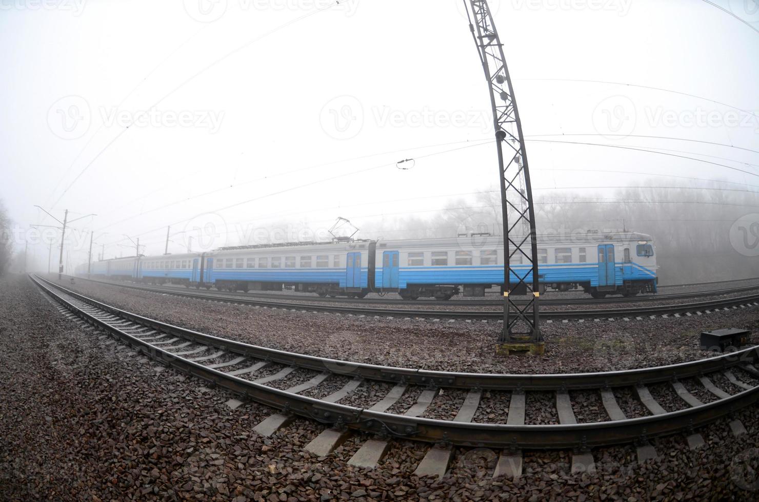 die ukrainische s-bahn rauscht an einem nebligen morgen die eisenbahn entlang. Fisheye-Foto mit erhöhter Verzerrung foto