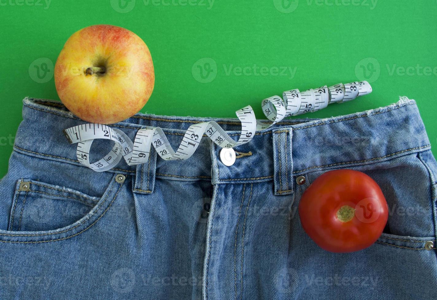 Jeans, Zentimeterband, Tomate und Apfel foto