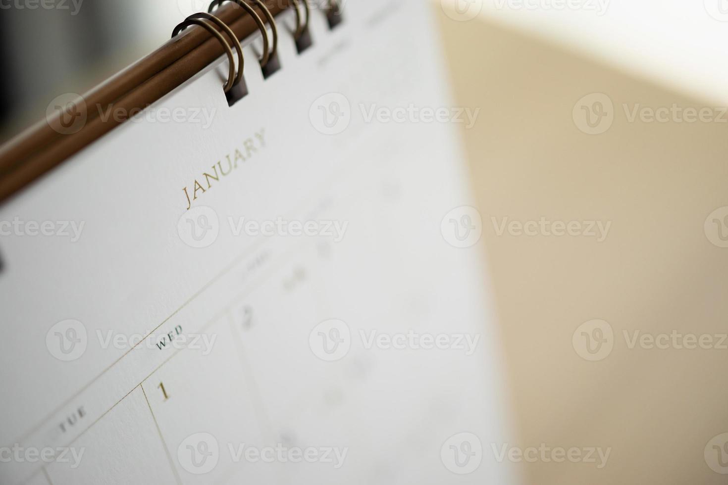 kalenderseite nahaufnahme im januar auf holztischhintergrund geschäftsplanungstermin tagungskonzept foto