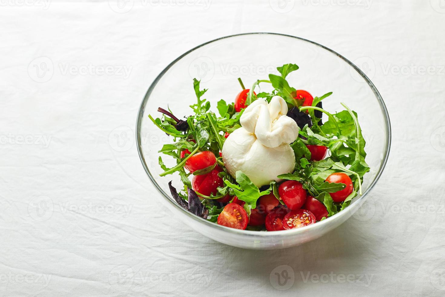 Burrata, italienischer Frischkäse aus Sahne und Büffel- oder Kuhmilch, mit Tomaten, Rucola und rotem Basilikumsalat foto