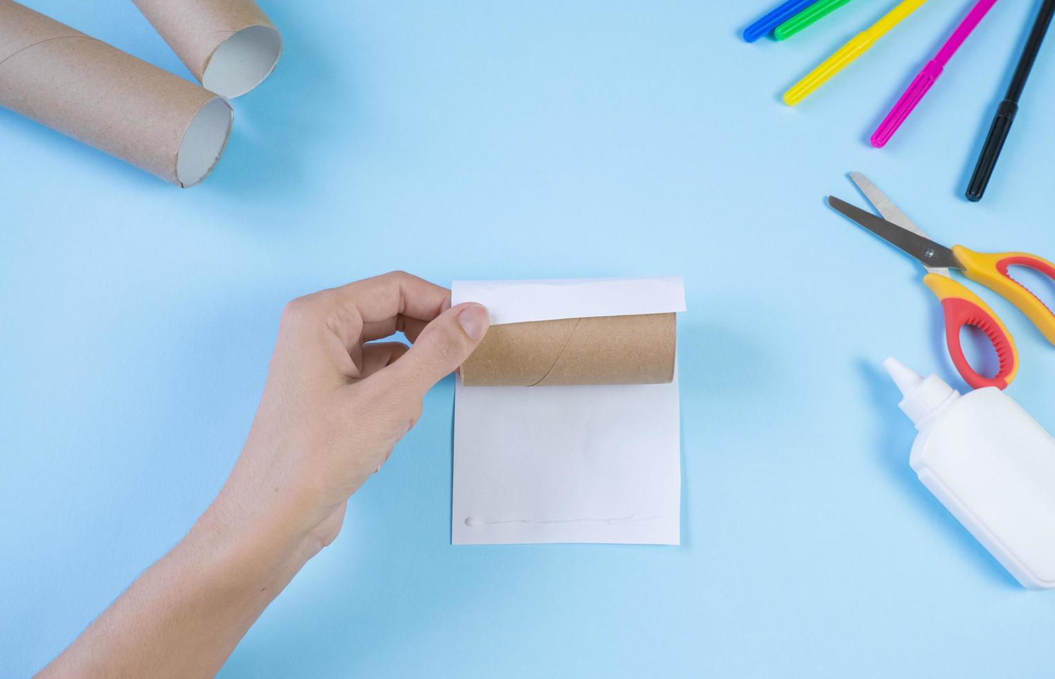 festliches einfaches basteln für kinder. Rolle Toilettenpapier Spielzeugbär auf blauem Hintergrund. kreative dekoration umweltfreundlich, wiederverwendung, recycling, minimales abfallfreies handgemachtes konzept foto