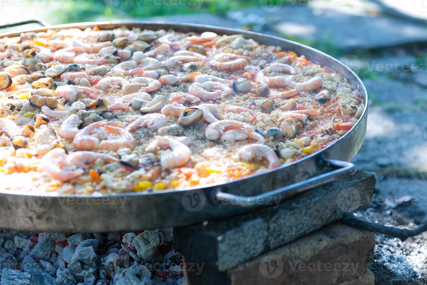 Paella in großer Pfanne zubereiten foto