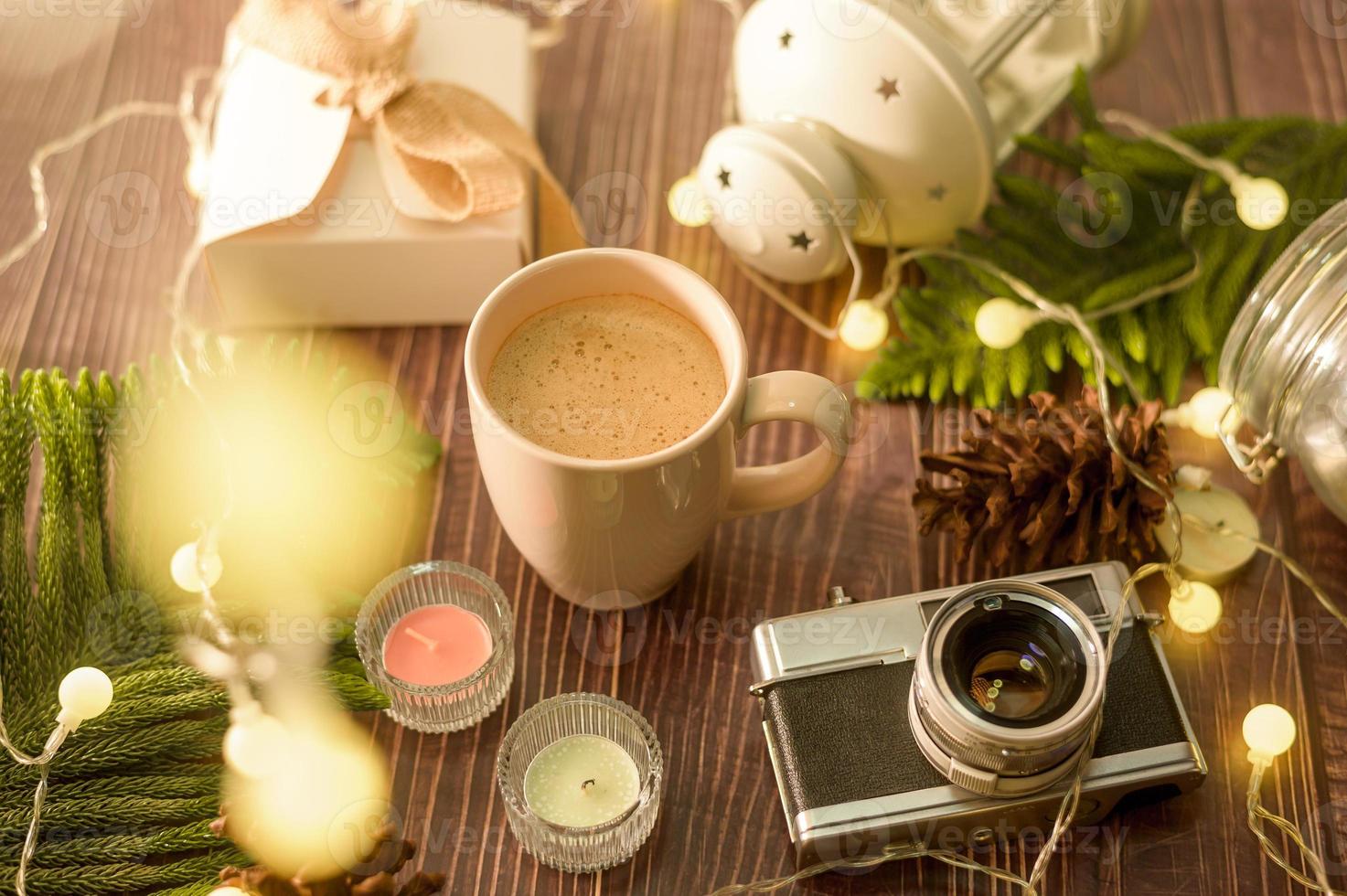 kaffeetasse über weihnachtsbeleuchtung bokeh zu hause auf holztischdekorationen. winterurlaubsdekoration, weihnachts- und neujahrsdekorationskonzept foto