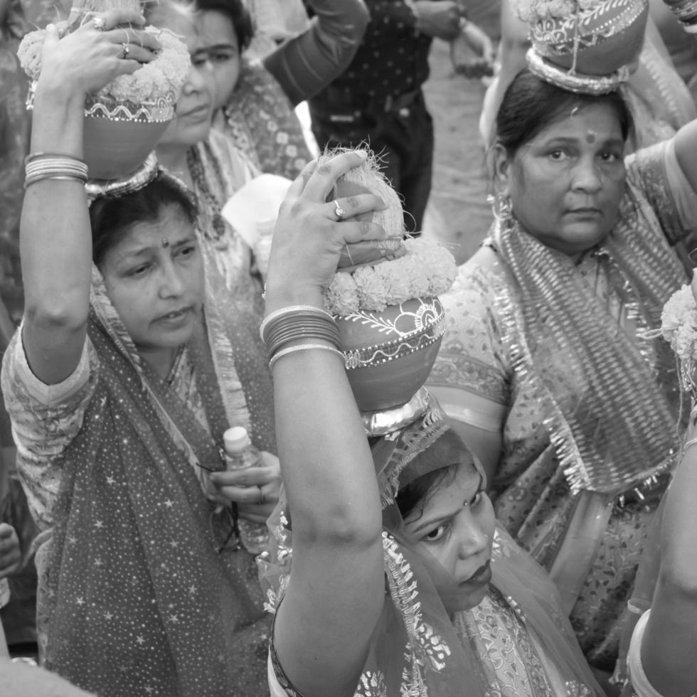 delhi, indien 03. april 2022 - frauen mit kalash auf dem kopf während des jagannath-tempels mangal kalash yatra, indische hindu-anhänger tragen irdene töpfe mit heiligem wasser mit kokosnuss auf der oberseite - schwarz und weiß foto