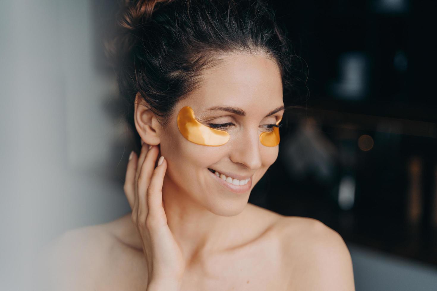 hübsche Frau mit Hydrogel-Patches auf der Haut unter den Augen. Hautpflegebehandlung, Anti-Aging-Schönheitsroutine foto