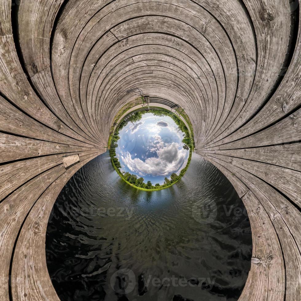 blauer kugel kleiner planet innerhalb der umwandlung von holzsteg und see. foto