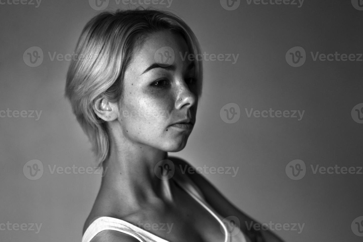 Porträt einer jungen traurigen Frau, die wegschaut, dunkles Schwarz-Weiß-Foto foto