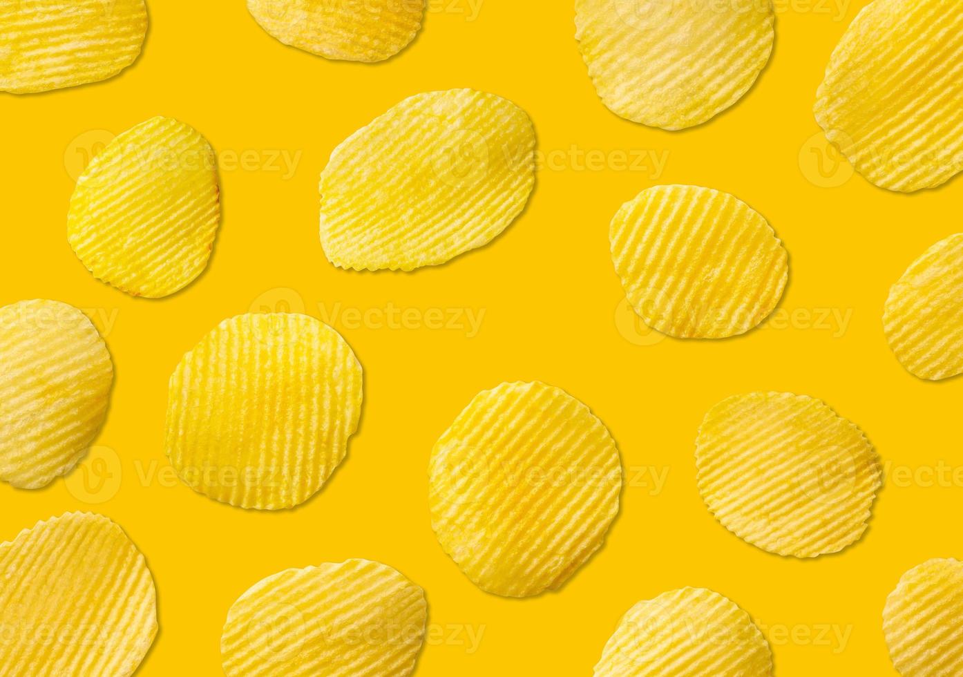 Kartoffelchips Muster auf gelbem Hintergrund Draufsicht flach liegen foto
