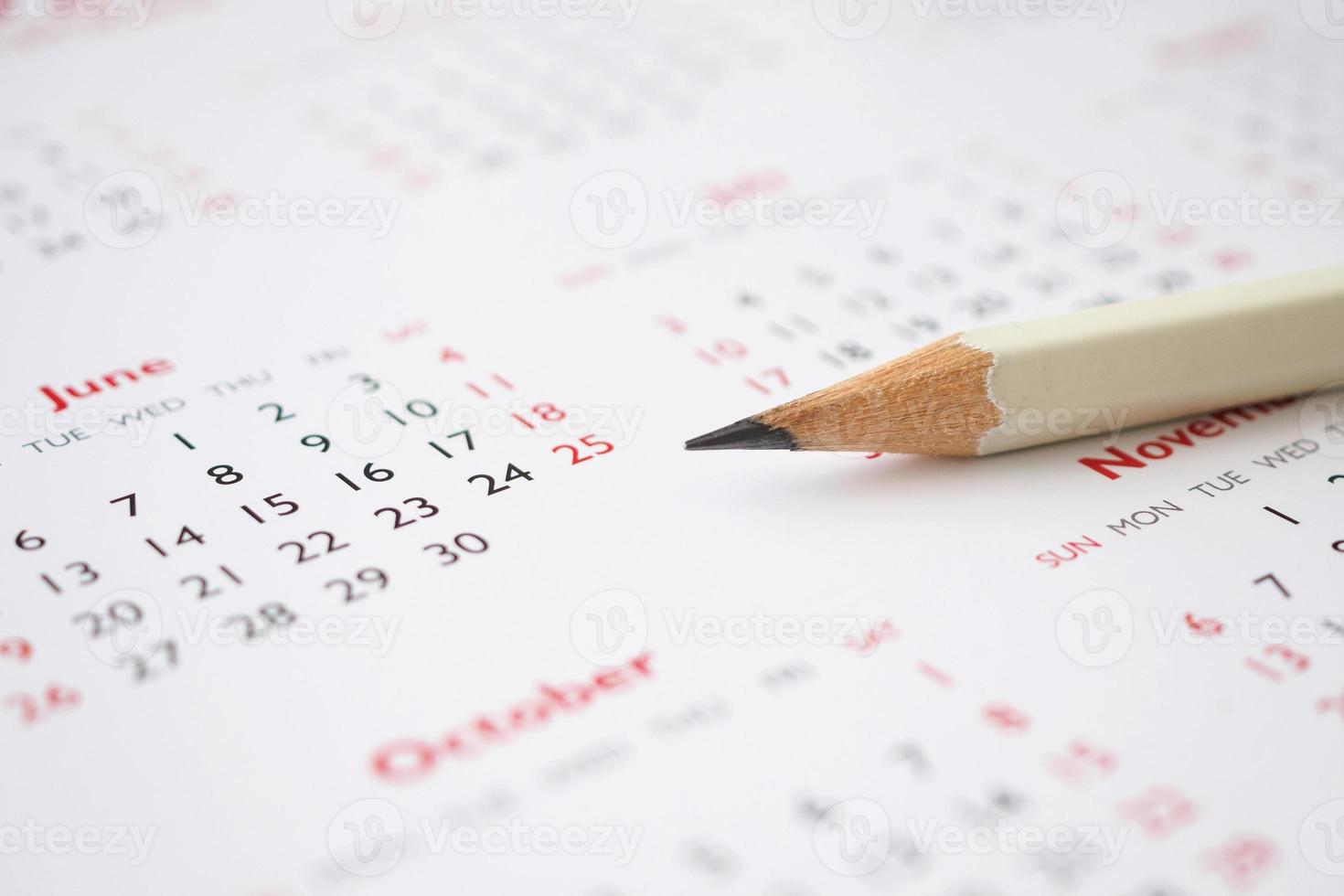 weißer Bleistift auf Kalenderhintergrund Geschäftsplanung Termin Meeting Konzept foto