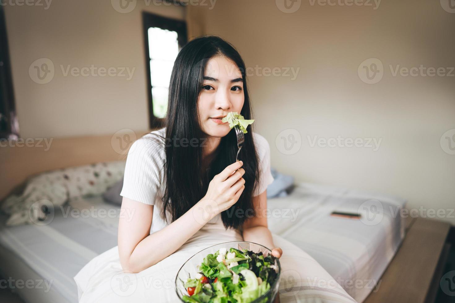 junge erwachsene asiatin essen gemüsesalat frühstück für diät foto