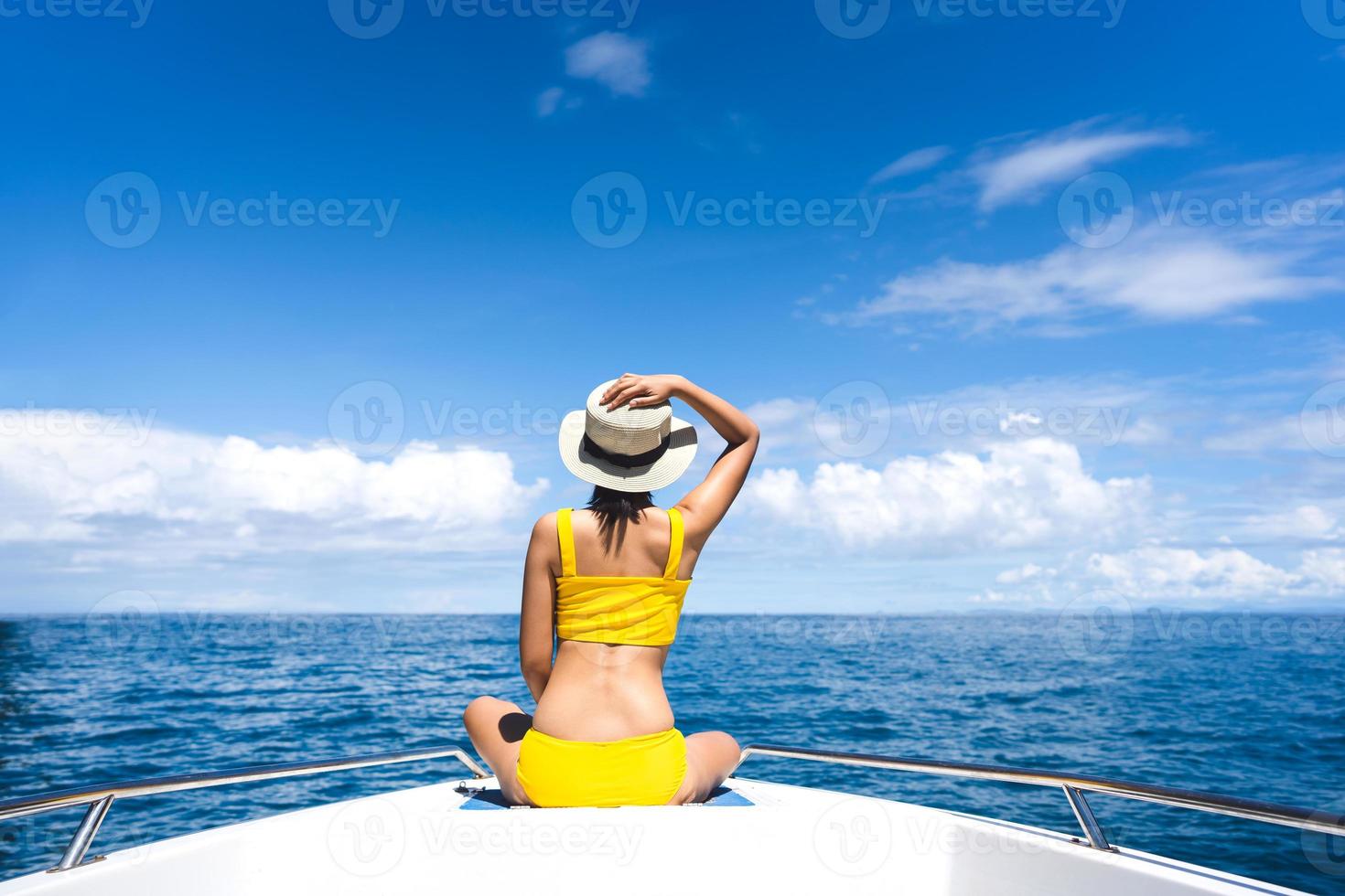 junge erwachsene reisende frau sitzen auf dem segelboot mit summe blauem himmel und meer foto