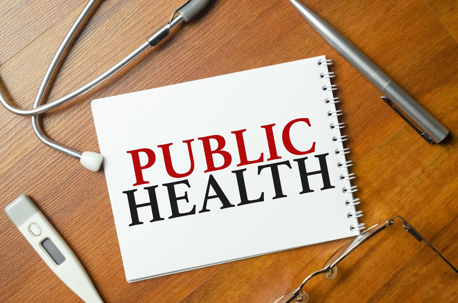 Wort öffentliche Gesundheit mit Stethoskop auf Holzhintergrund foto