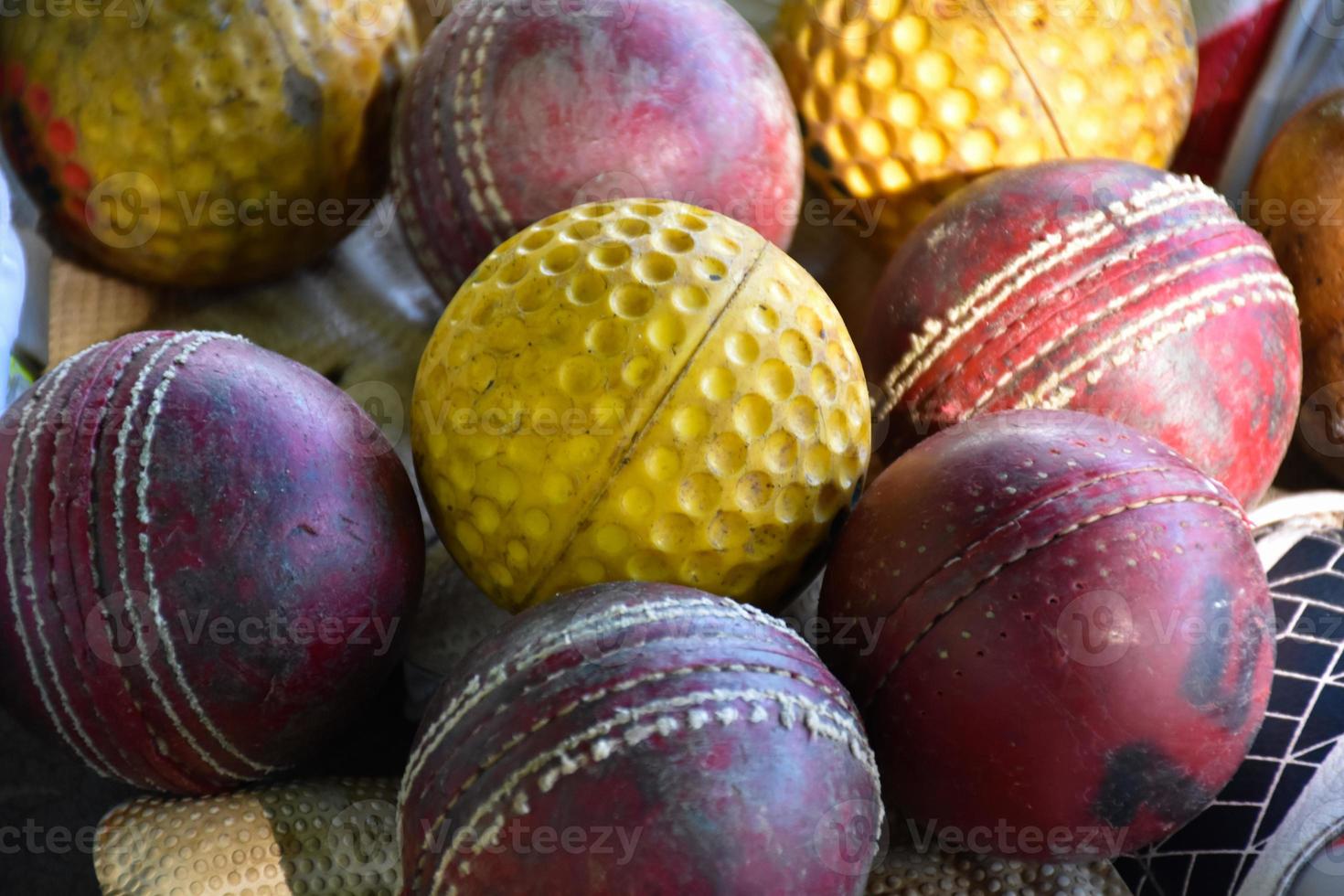 training von cricket-sportgeräten auf dem boden, lederball, handschuhe und schläger, weicher und selektiver fokus auf den ball. foto