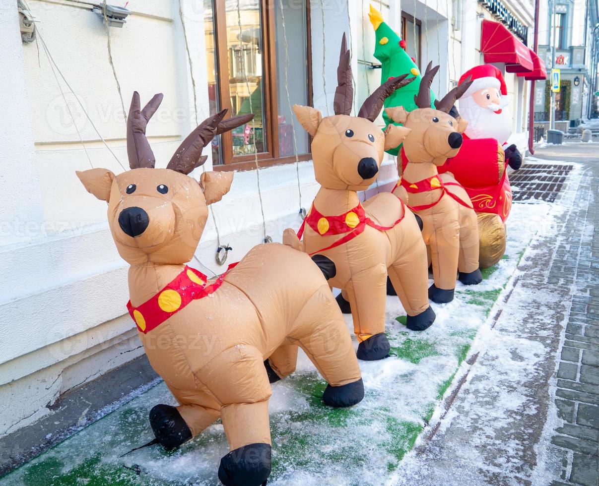 aufblasbarer weihnachtsmann und rentier auf der straße. Weihnachtsdesign. neujahrsdekoration auf der straße. die Atmosphäre des Urlaubs. foto