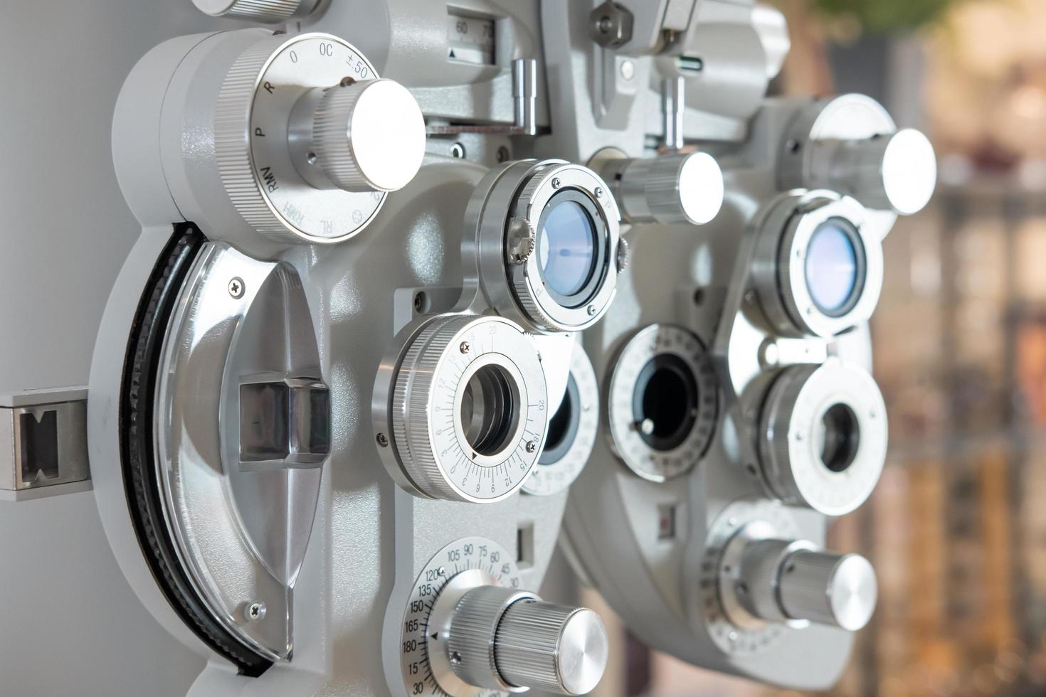 selektiver fokus auf optometrierahmenausrüstung. mit verschwommenem Hintergrund, während der Optometrist das Sehsystem des Auges älterer Patientinnen mit einer professionellen Maschine untersucht, bevor er eine Brille herstellte. foto