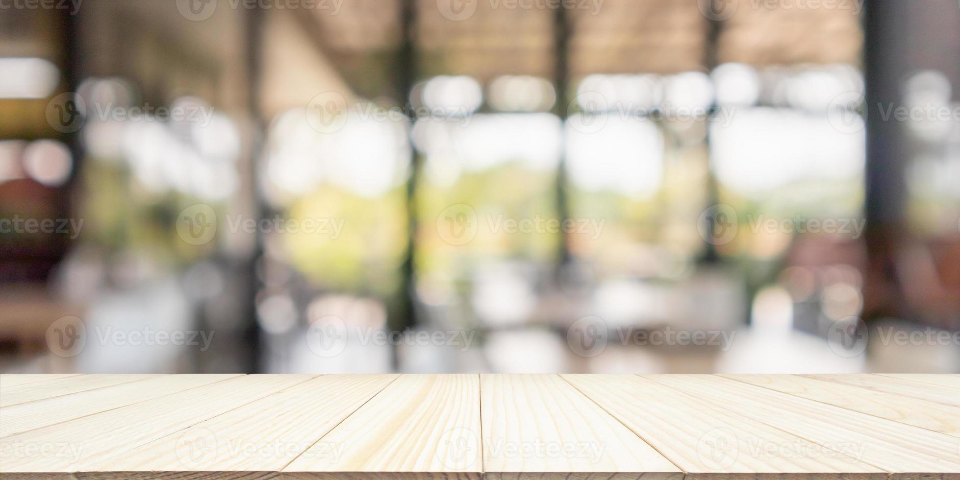 leere hölzerne tischplatte mit caférestaurantinnenraumunschärfehintergrund foto