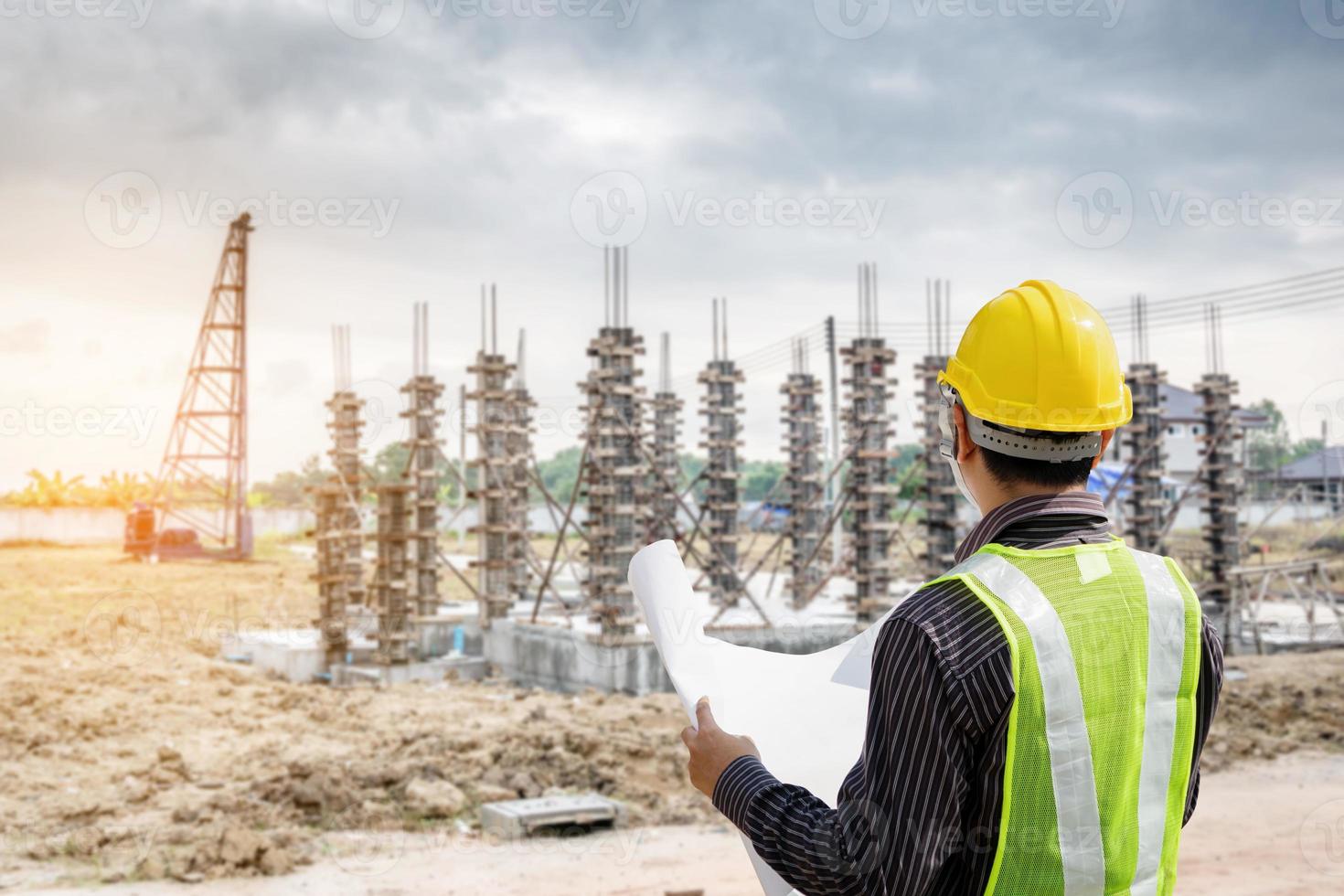 professioneller ingenieur in schutzhelm und blaupausenpapier auf der baustelle des hausbaus foto