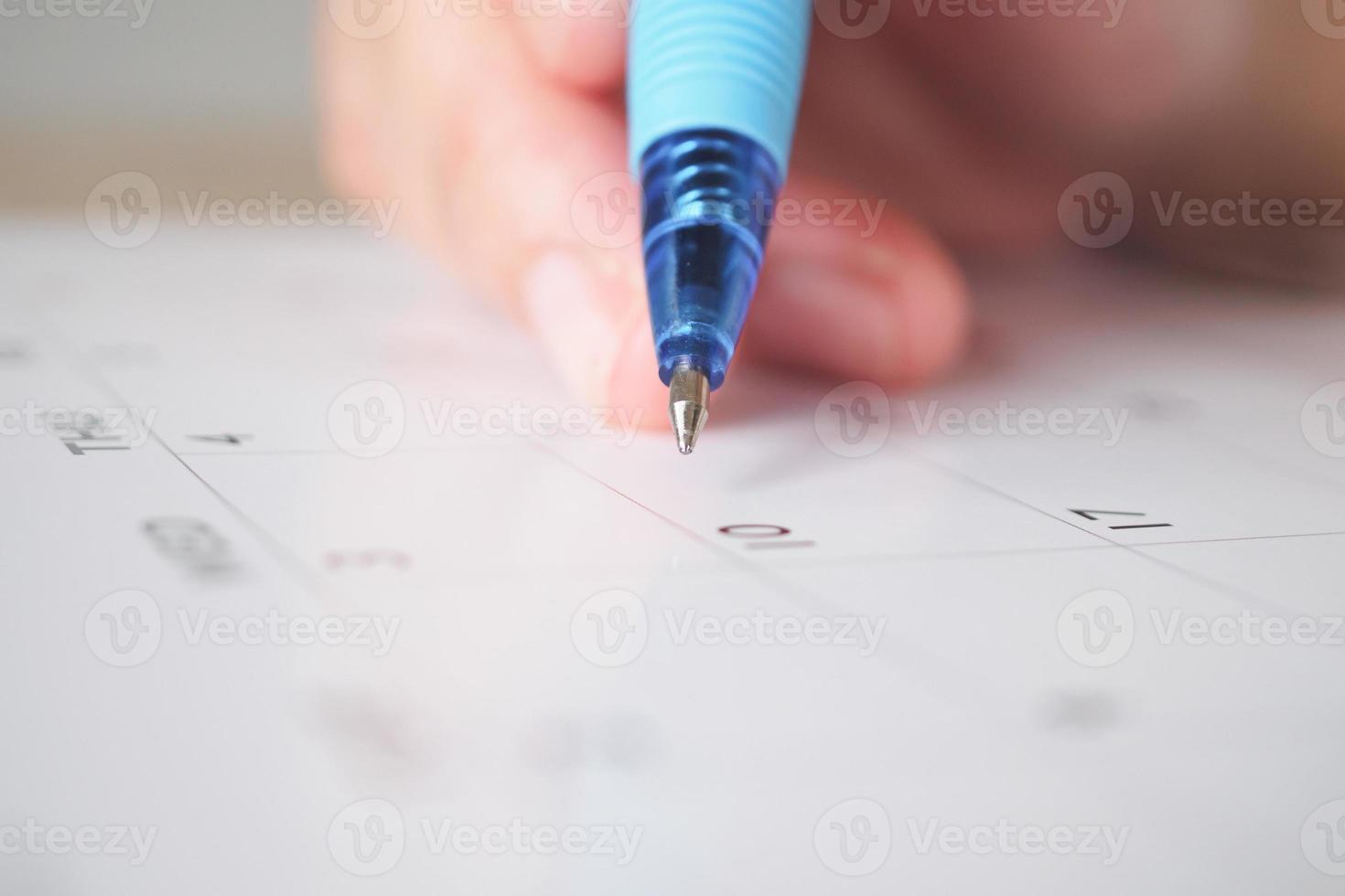 Frauenhand mit Stift schreiben auf Kalenderdatum Geschäftsplanungstermin Besprechungskonzept foto