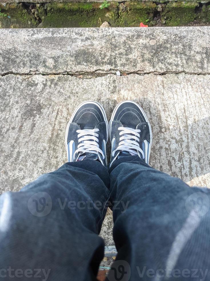 Schuhe und Jeans, ein Foto von der Fußspitze eines stehenden Mannes