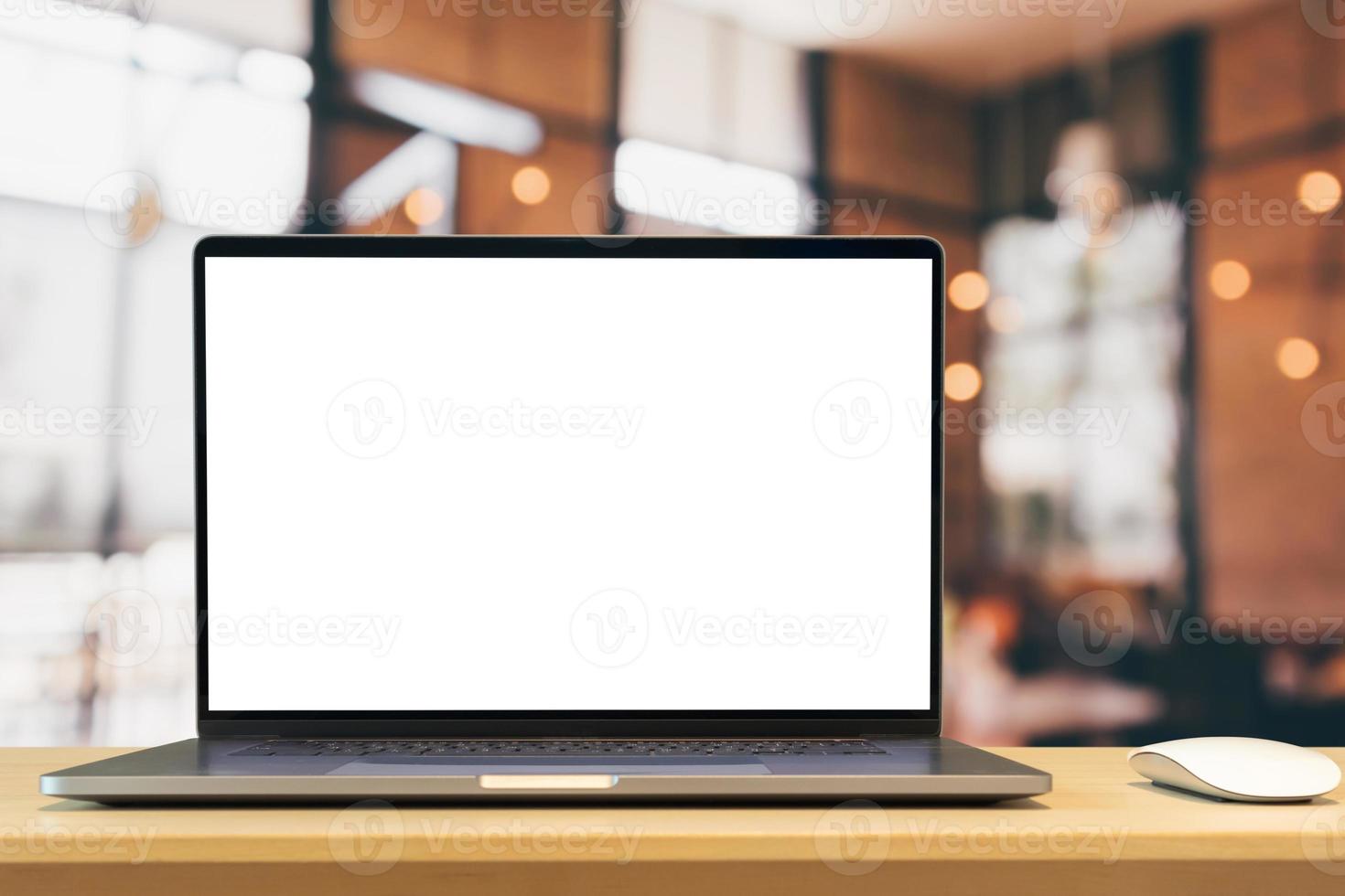 Laptop mit leerem Bildschirm auf Holztisch mit Café-Coffeeshop-Unschärfehintergrund foto