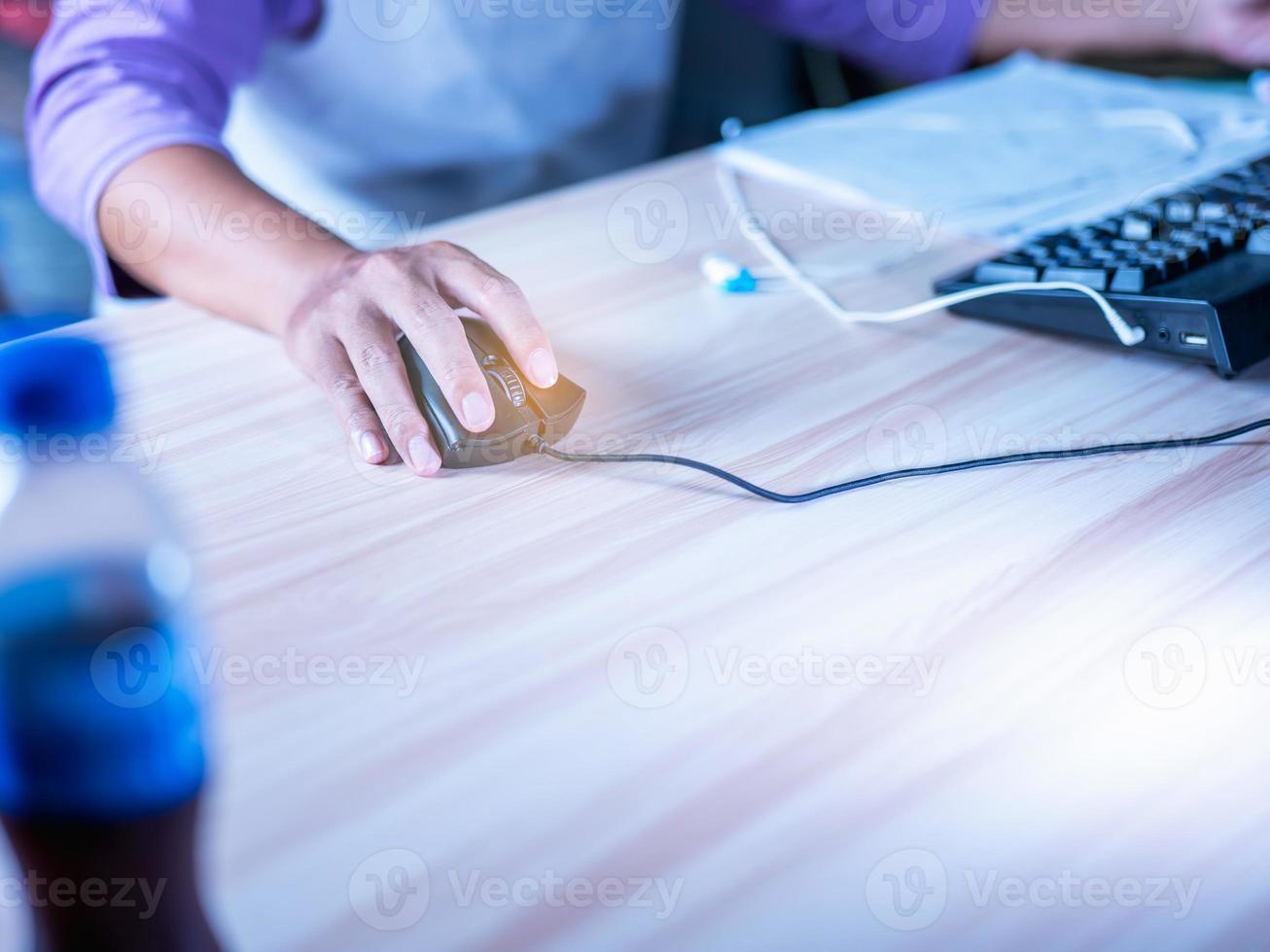Focus Handle Schwarze Maus mit langem Kabel Verwenden Sie Ihren Finger, um sowohl die linke als auch die rechte Taste zu steuern, um zu arbeiten. auf dem Arbeitstisch, hellbraune Holzmaserung. ohne Mauspad foto
