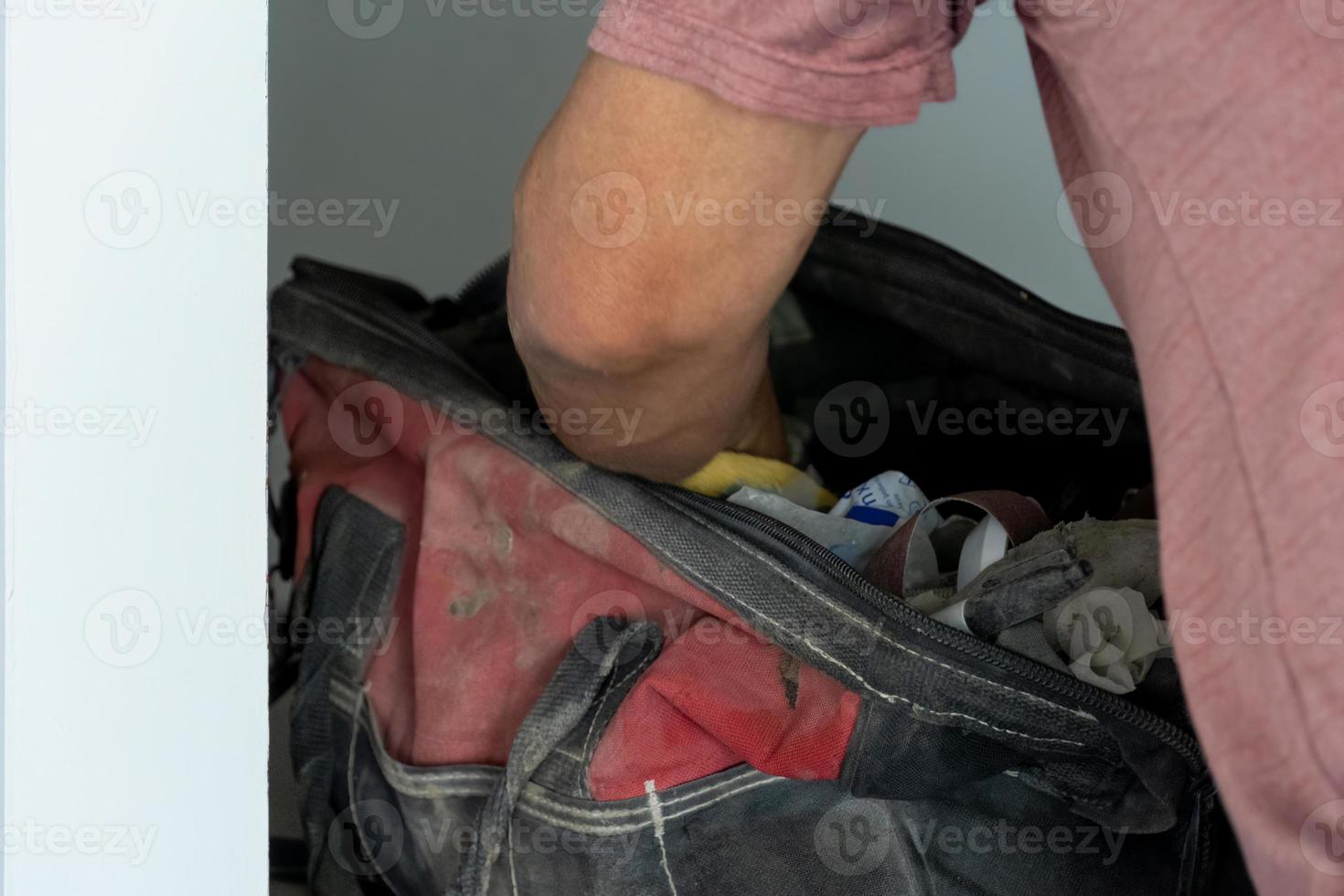 Latino-Mann auf der Suche nach Werkzeugen in seinem Werkzeugkasten, hispanisch, mit Schraubendreher in der Hand foto