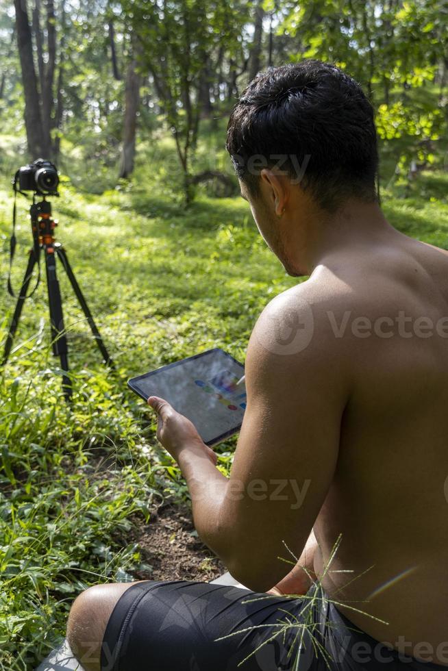 junger mann erklärt das zeichnen auf seinem tablet, während er chakra-, yoga- und meditationsunterricht gibt, mexiko foto