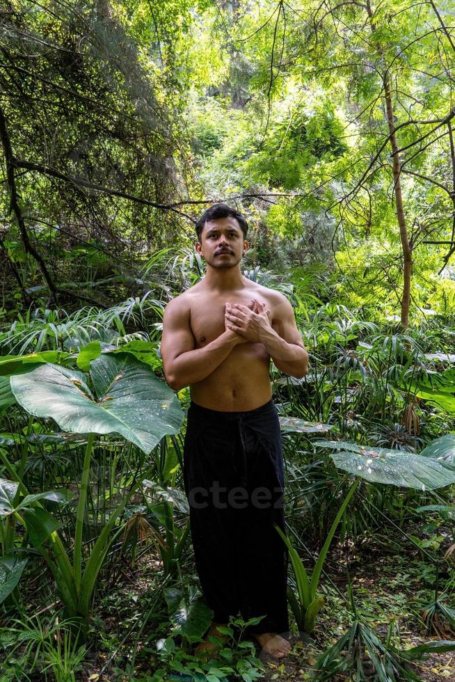 Junger Mann, der auf einer Treppe in einem Wald, Mexiko, meditiert foto