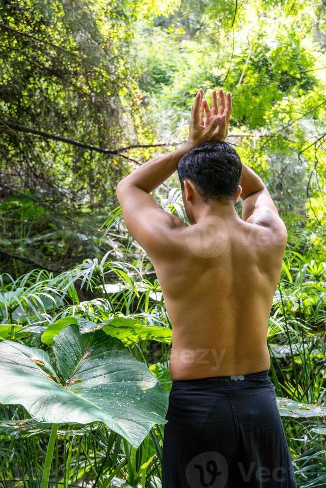 Junger Mann, der auf einer Treppe in einem Wald, Mexiko, meditiert foto