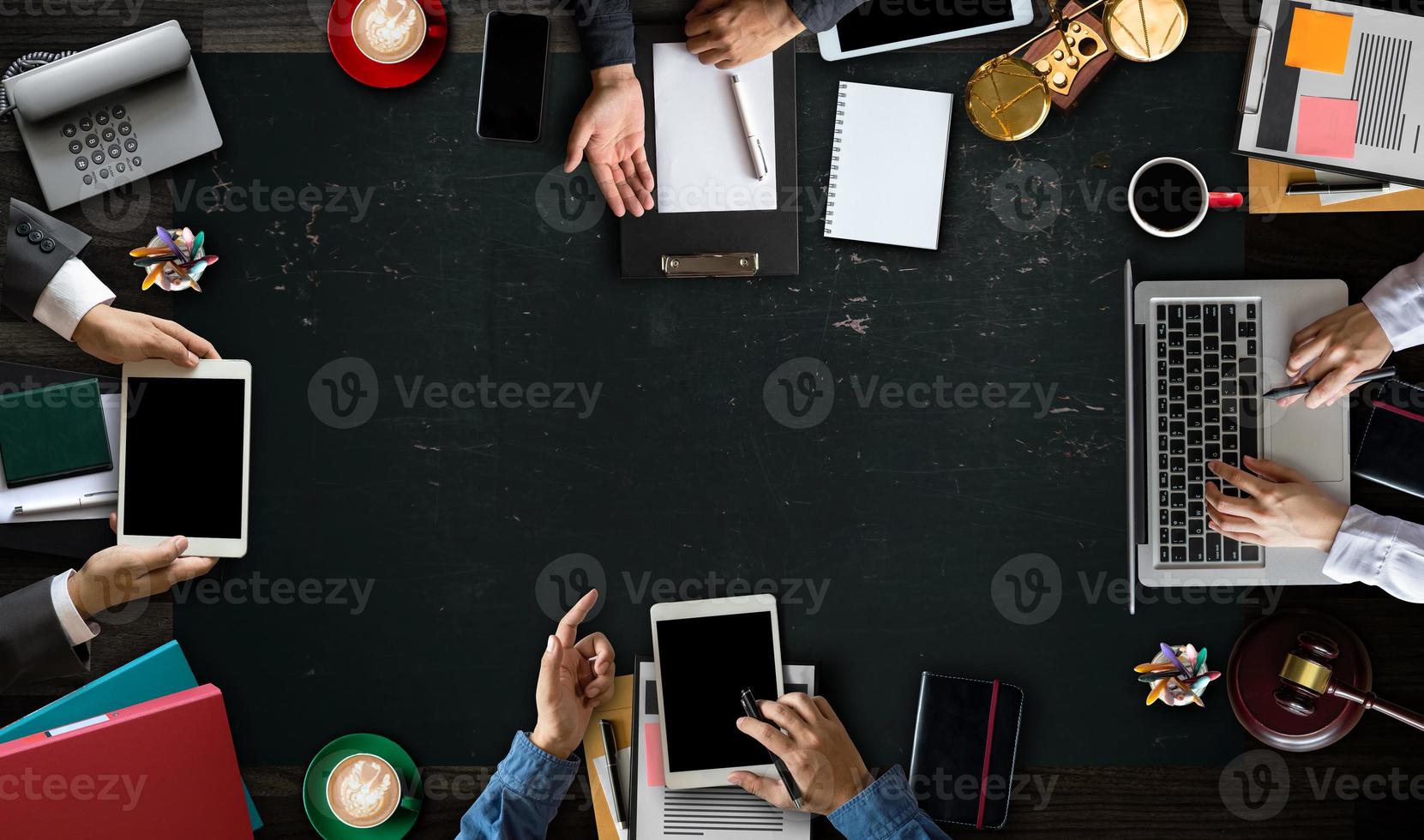 Geschäftsleute und Anwälte von oben diskutieren Vertragspapiere mit Messingwaage auf dem Schreibtisch in einem modernen Büro. recht, juristische dienstleistungen, beratung, justiz und rechtskonzept. foto