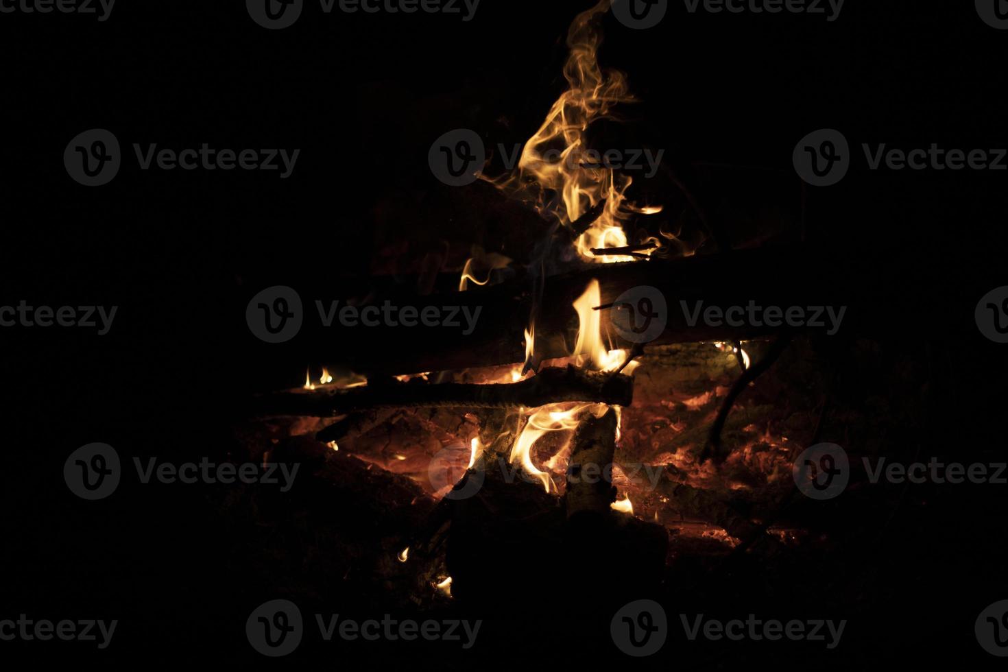 Lagerfeuer im Dunkeln. Flammen in der Nacht. brennendes Holz. Campingdetails. foto