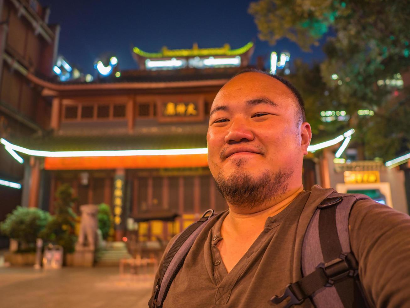 Portrail-Foto eines asiatischen Reisenden im Huogongdian Food Garden Eingangstor in der Stadt Changsha, China. Changsha ist die Hauptstadt und bevölkerungsreichste Stadt der Provinz Hunan in China foto