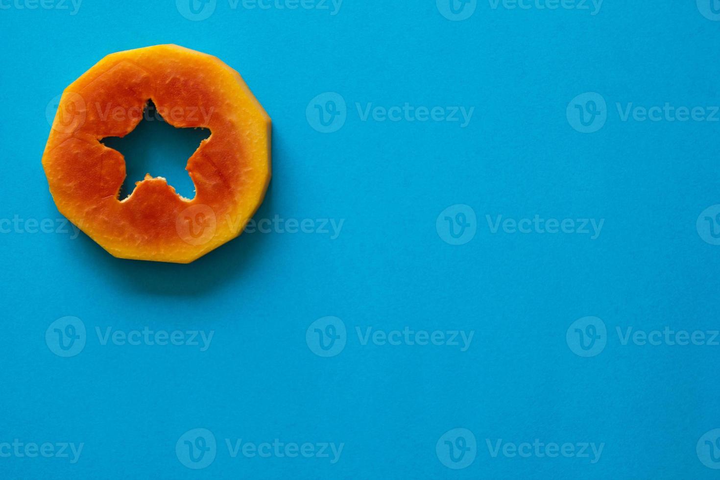 ein Stück orange Papaya auf blauem Hintergrund. foto