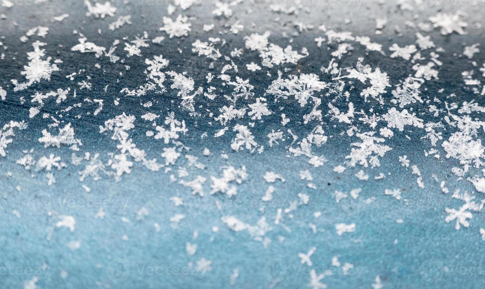 Schneeflocken auf blauem Hintergrund. nahaufnahmeschneebeschaffenheit, natürlicher weihnachtshintergrund foto