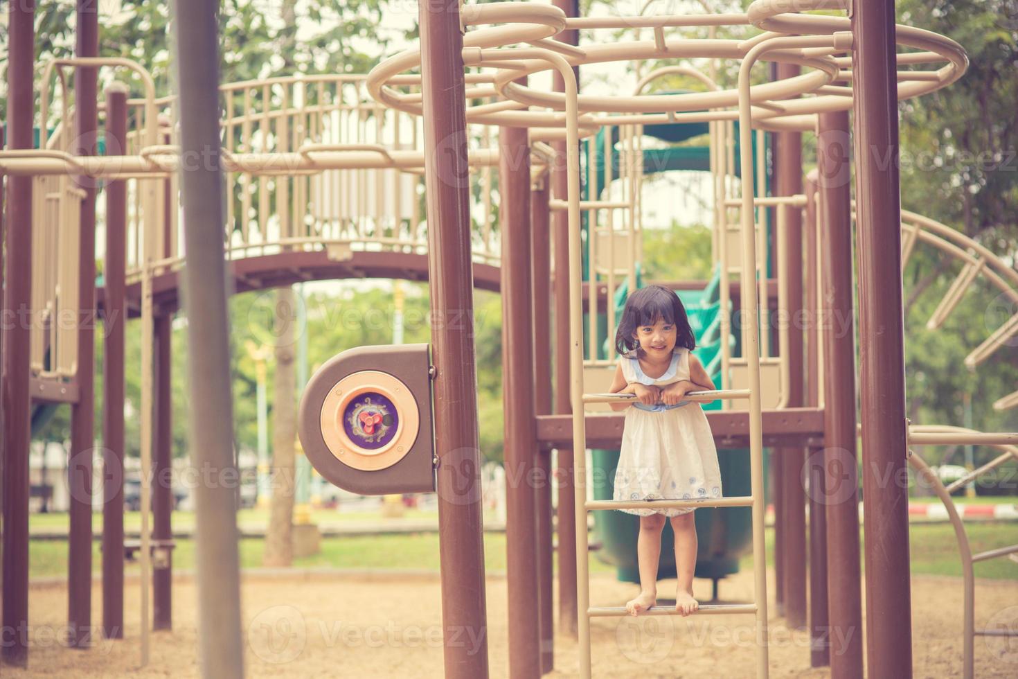 aktives kleines Mädchen auf dem Spielplatz foto