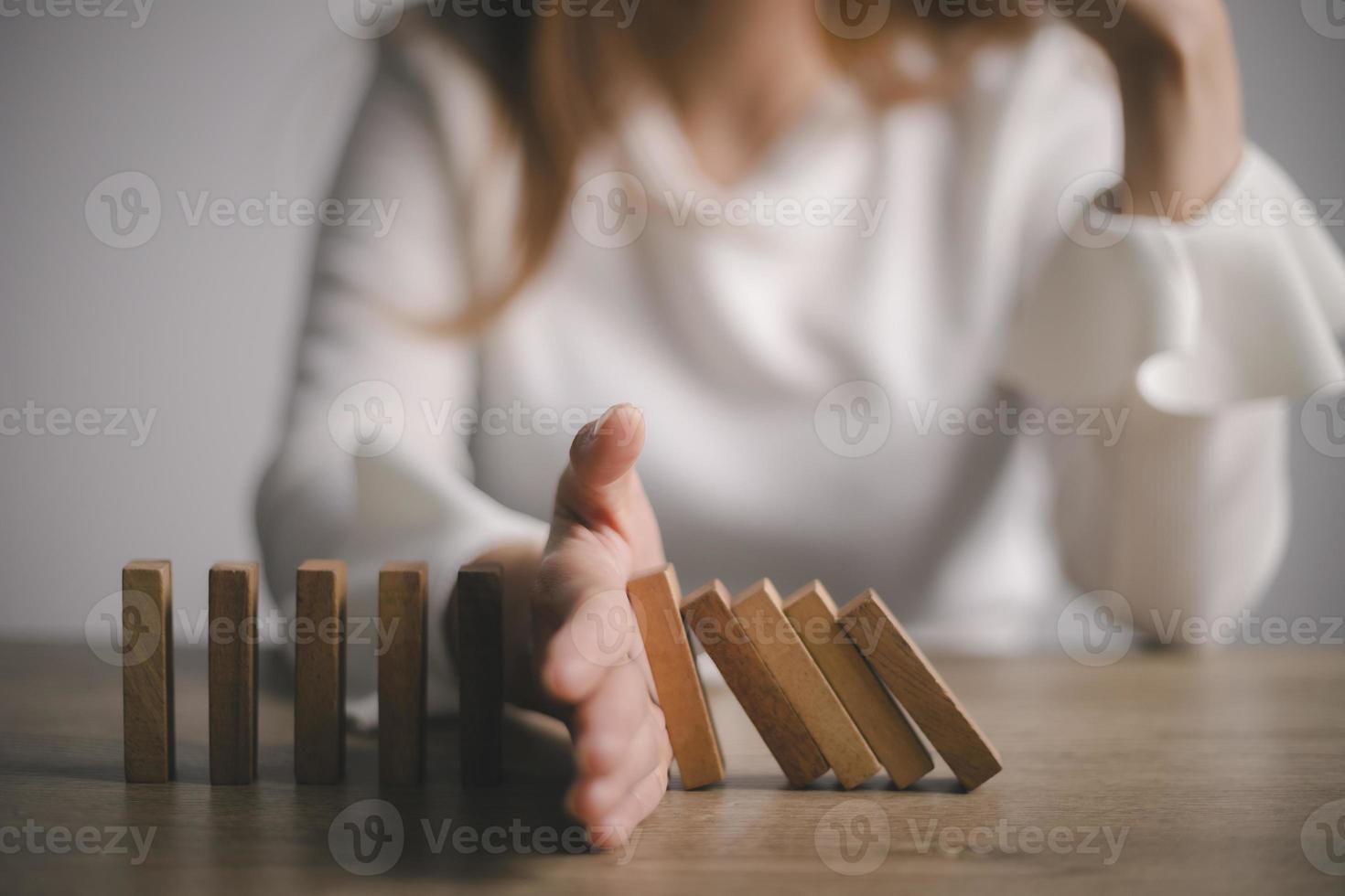 risiko und strategie im geschäft, handstoppender holzblock-domino-geschäftskriseneffekt oder risikoschutzkonzept, prävention und entwicklung zur stabilität foto