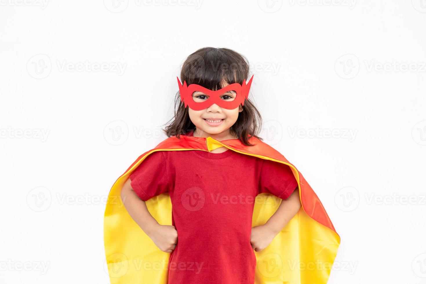 Kinderkonzept, lächelndes Mädchen, das Superheld auf weißem Hintergrund spielt foto
