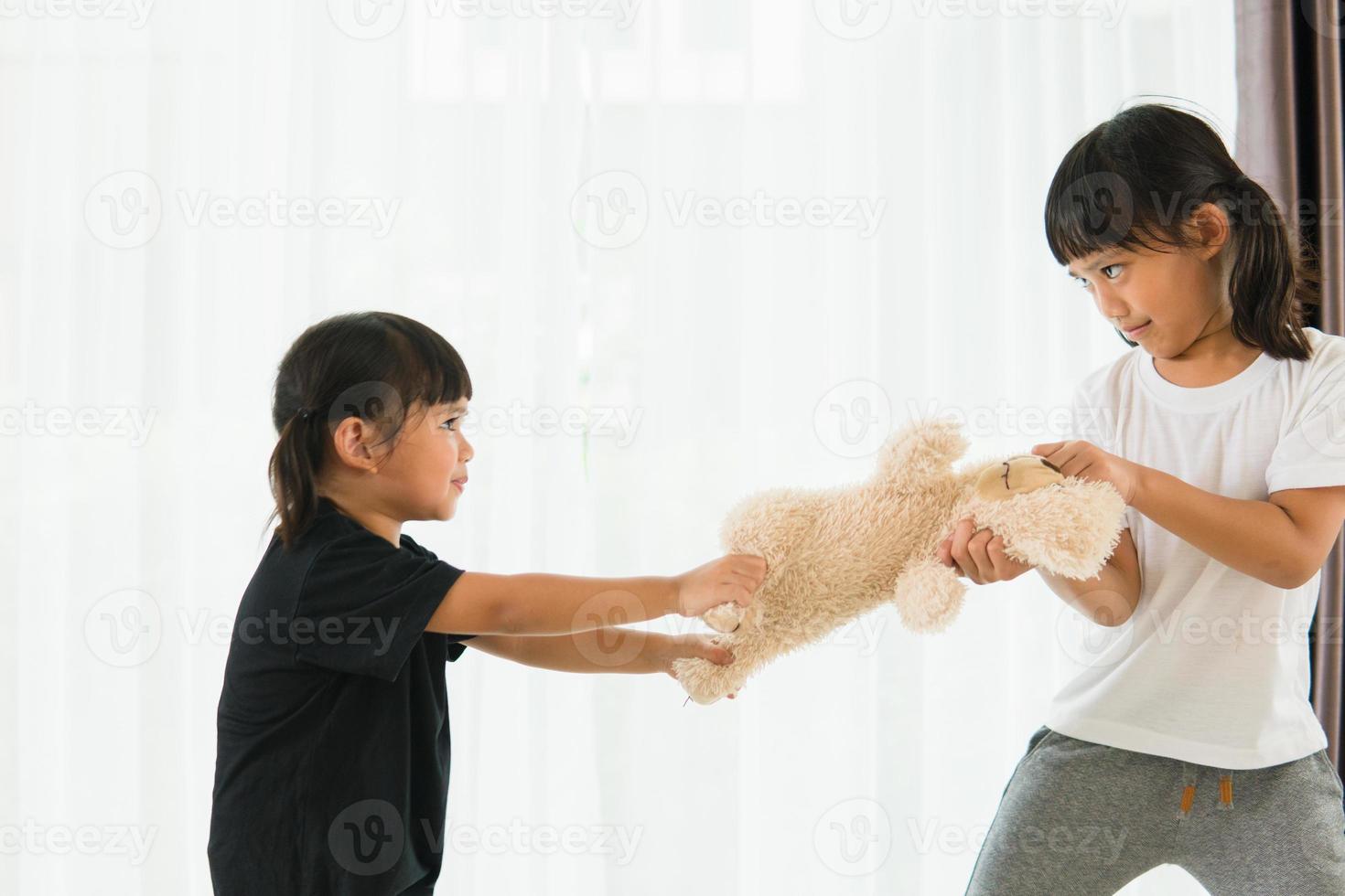 zwei kleine Mädchen streiten sich um den Bären foto