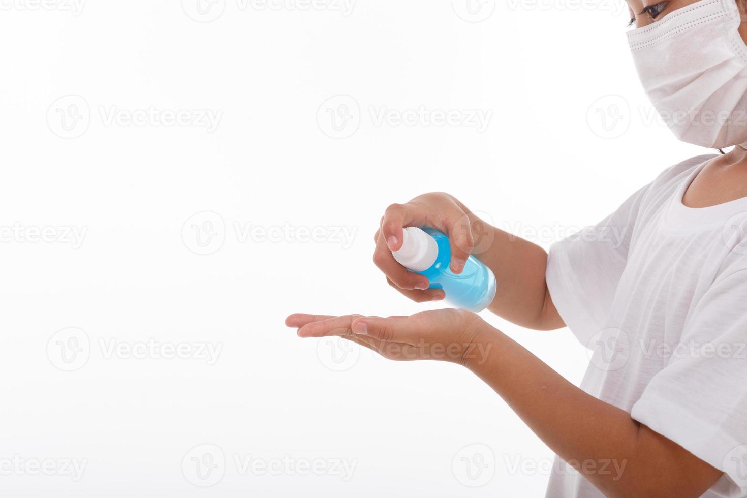 kleines Mädchen, das Alkoholgel zum Reinigen der Hände verwendet. auf weißem Hintergrund foto