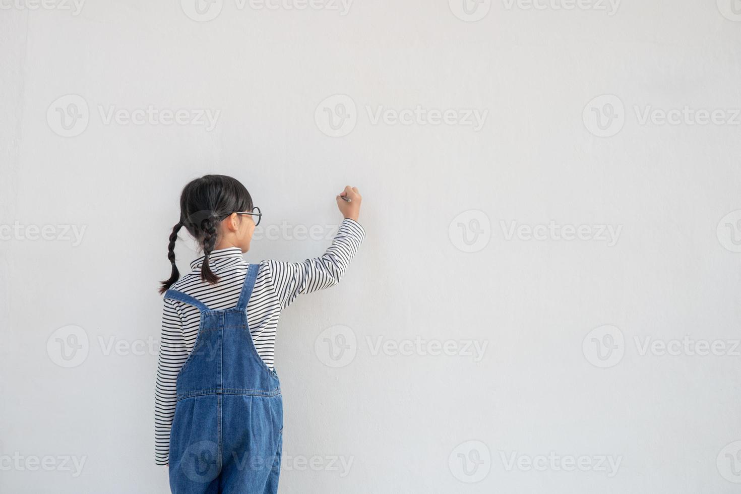 kleine kinder malen auf weißer wand foto