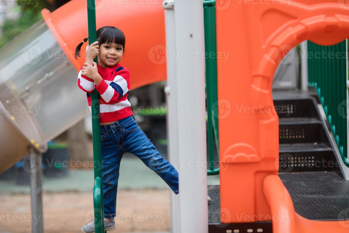 aktives kleines Mädchen auf dem Spielplatz foto