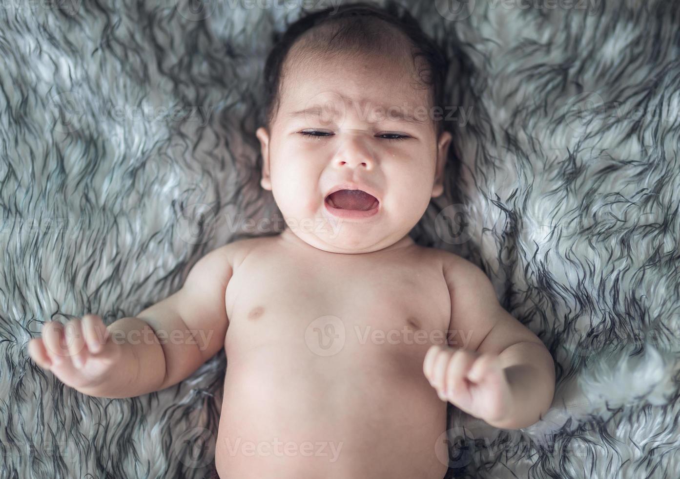 Babymädchen weint in einem Wickel foto