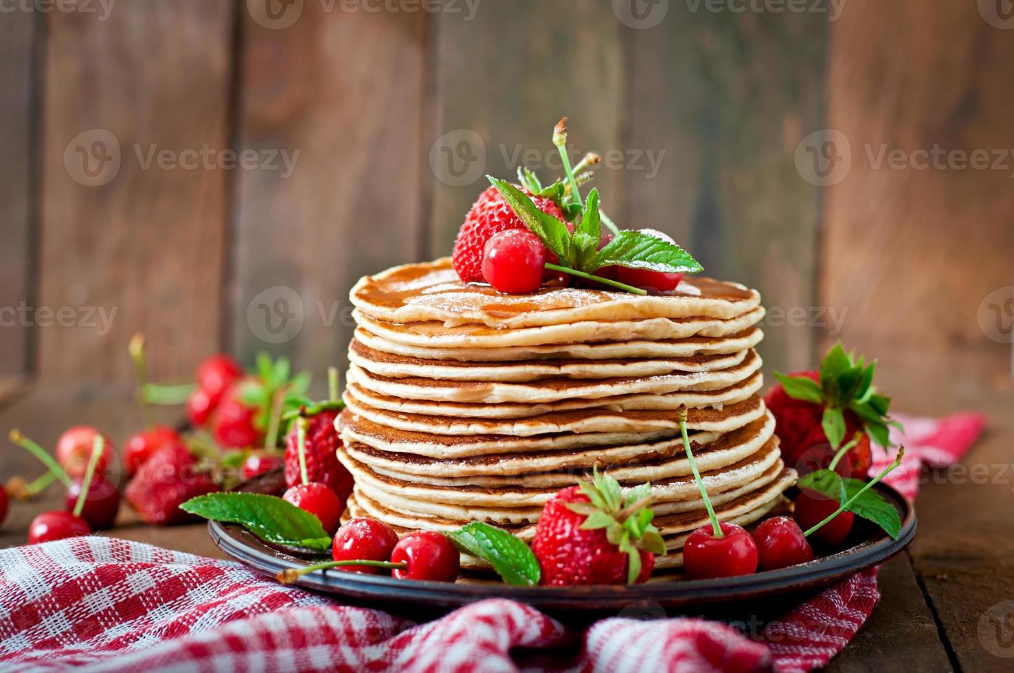 Pfannkuchen mit Beeren und Sirup im rustikalen Stil foto